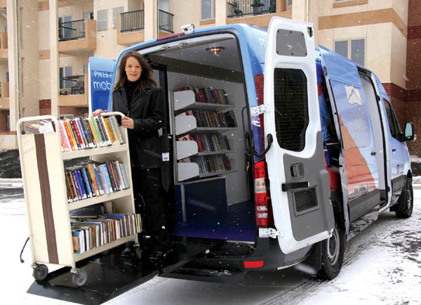 Lobby Stops van driver Lisa Ward shows that even snowfall cant prevent a rack of books from being lowered on the 
electronic lift, preparatory to being wheeled into one of the 15 assisted-living locales on her route  in this case the Village at Skyline on the Westside.
Westside Pioneer photo