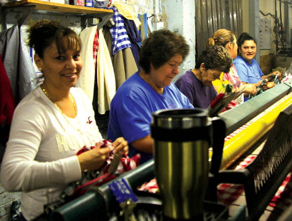 Keeping a steady flow of clean, wet tablecloths through an
apparatus that quickly dries them are Sno-White employees
(from left) Brenda Martinez, Juana de Caballero, Mercy Montoya, Maria de Caballero and Trini Reyes.
Westside Pioneer photo