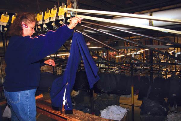 Sally Nunez, a Sno-White plant supervisor and 26-year
employee, sends uniforms down whats nicknamed the
Spider  so called that because the customized, gravity-
operated mechanism looks like a web as hangers for each
uniform slide down a network of pipes that eventually sorts
them into the orders for the appropriate customers. Tickets directing the flow can be seen, clipped above.
Westside Pioneer photo