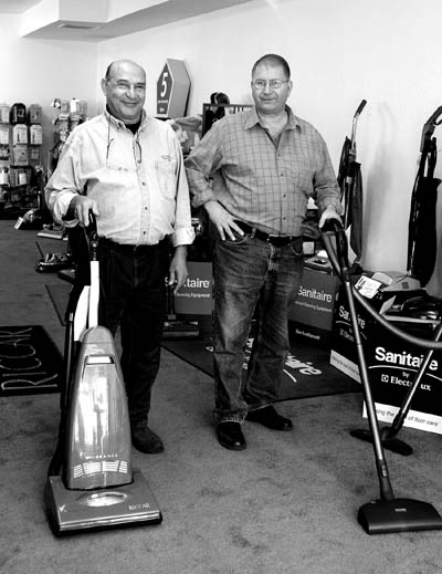 Dwight Griggs (right) shows off a canister vacuum and
employee Tony Rodasta an upright in the showroom floor of
Griggs Vacuums (also known as the All Bag and Belt Shoppe) at 1706 W. Colorado Ave. 
Westside Pioneer photo