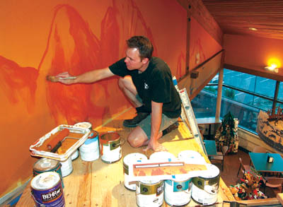 Douglas Rouse paints on a scaffold he had to custom-make 
to paint a mural above the cafeteria in the Garden of the 
Gods Visitor Center. The eating area and the centers 
first-floor south window can be seen at the lower right.
Westside Pioneer photo