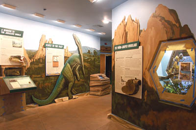 Trying to blend in with the work of previous artists, Rouses 
background rock paintings can be seen behind the existing 
exhibits, including the wall signage and the dinosaur, along the 
walkway to the Visitor Centers theater (background center of photo).
Westside Pioneer photo