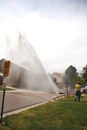 A Colorado Springs Utilities worker watches as the water
shoots into the sky, spraying rocks and dirt higher than the
nearby houses. It took close to an hour before Utilities
could shut down the water to the 50 houses affected in the Holland Park-area neighborhood, then crews started reparing the line in hopes of restoring service that 
night.
Katie Queen photo