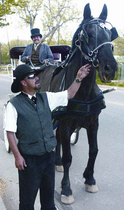 3Gs employee Geoff Gerdes talks to Sammy, the Old 
Colorado City carriage services recently acquired second horse, while owner/chief driver Mike Solano waits for the
next customer to climb on board.