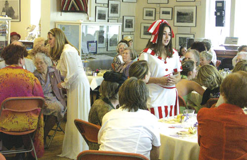 Britney Brown (in a 1940s cream nightgown and robe) and
Kelly Vinnola (in a 1920s swimsuit) talk to members of the
audience, seated at tables in the Old Colorado City History
Center.
Westside Pioneer photo