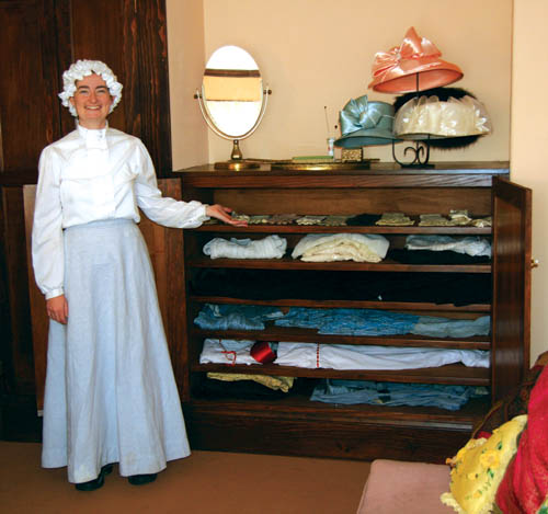 Dressed in period attire, Beth Harmon shows a cabinet that
was built for a restored Orchard House second-floor
dressing room. A docent for 12 years, Harmon served over
the past several months as interim interpreter for Rock
Ledge Ranch, but is now studying to be a physicians
assistant at CU Health Sciences in Denver. Elizabeth Barber, another long-time docent, recently took on the interpreter duties.
Westside Pioneer photo