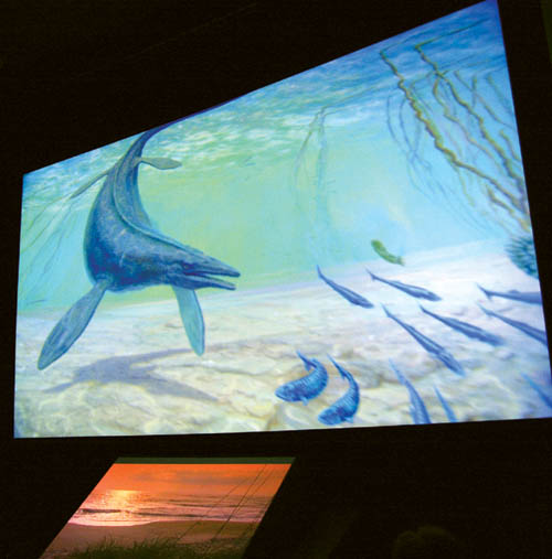  A prehistoric fish swims in an ocean that once swirled where the Garden of the Gods stands during the new version of the  
Visitor Center movie, How Did Those Red Rocks Get There? Below the main screen is the supplemental periaktoi screen device.
Westside Pioneer photo