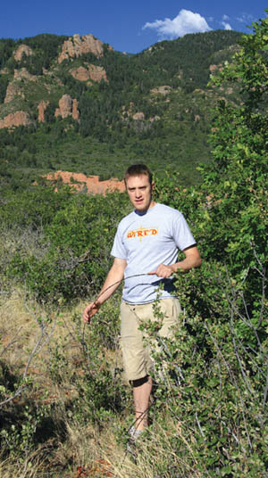 Clint Tafoya, who has been a renter/caretaker on the
White Acres for the past eight years, shows rolled-up
barbed wire that once marked the boundary between the 
Bock property (now Red Rock Canyon Open Space) and White Acres. In the background are rock formations in Section 16.
Westside Pioneer photo