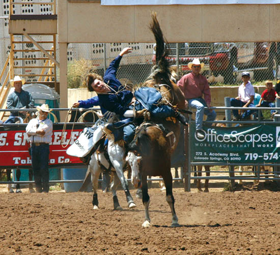 Jerad Schlegel of Burns, Colo., is about to take a hard fall
(he walked it off)  after completing the necessary eight
seconds for a time during the bareback riding competition at the Pikes Peak or Bust Rodeo finals July 15.  
Westside Pioneer photo