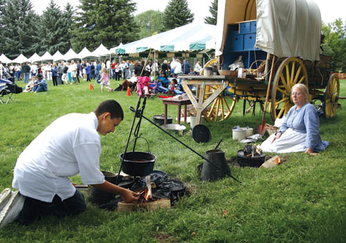 Fiddles, Vittles & Vino scenes at Rock Ledge Ranch Aug. 23... While attendees check out the food-and-drink 
sampling booths Kyle Green and Christine Nekl keep the chuckwagon fires burning for cooking demonstrations.
Westside Pioneer photo