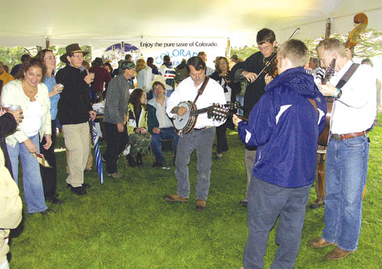 Unable to play on the Orchard House east stage 
because of a leaking tarpaulin cover, the Stanleytones play unamplified bluegrass under the wine and food tent, to the delight of event attendees. 

NOTE: For a short movie clip of the Stanleytones playing 
earlier that day, click the photo. 
Westside Pioneer photo