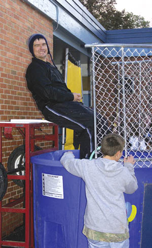 Washington Principal Terry Martinez shares a laugh with a student while waiting for the next youngster to aim at the 
dunk tank target during the schools Fall Carnival Oct. 20.
Westside Pioneer photo