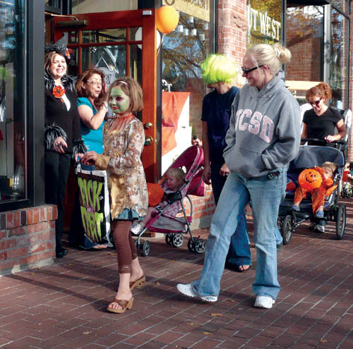 Standing in the doorway of the store, Ashley Treweeke (left) and Jessica Carabajal of the Calabash gallery enjoy 
handing out candy and viewing costumed kids during Safe Treats in Old Colorado City Oct. 31.
Westside Pioneer photo