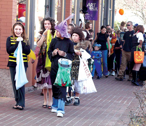 A steady stream of trick-or-treaters, some of whom are
wasting no time enjoying their gains, moves east along the
2500 block of West Colorado Avenue during Safe Treats
Oct. 31. The tall, smiling lady facing toward the sidewalk
under the Art Walk sign is Carrie VanVoltenberg of the
Squash Blossom gallery, who was giving away candy on
behalf of the store.
Westside Pioneer photo