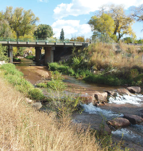 Fountain Creek burbles under the Highway 24 bridge east
of 21st Street in this file photo that also shows a city-built,
flow-controlling drop structure in the foreground. The creeks relatively sharp turns on either side of the bridge could be partially straightened as part of the Westside 
Highway 24 expansion project.
Westside Pioneer file photo