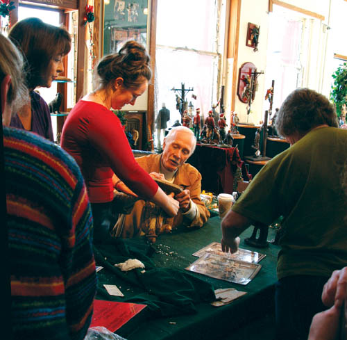 Michael Garman signs a sculpture his daughter Vanessa handed him during his last scheduled appearance at his Old Colorado 
City gallery Nov. 22-23.
Westside Pioneer photo