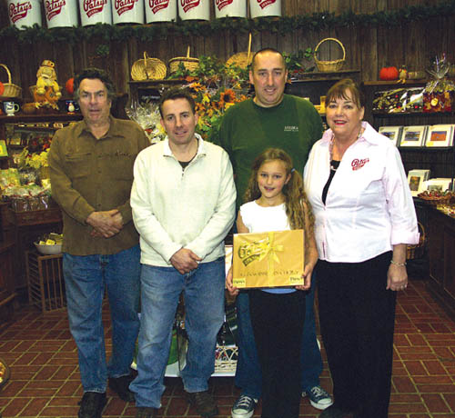 Three Niswonger generations are shown inside the Patsys Candies retail store. From left are Wes, his sons Mike and 
Si, Sis daughter Georgia and Wes wife Annette.
Westside Pioneer photo