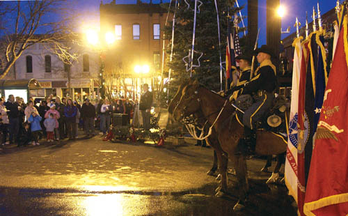 Soldiers in the Fort Carson Mounted Color Guard sit astride
their horses while the emcee, retired Army Col. Dave
Hughes, stands on the podium in front of event attendees and the soon-to-be-lit Honor Tree.
Westside Pioneer photo